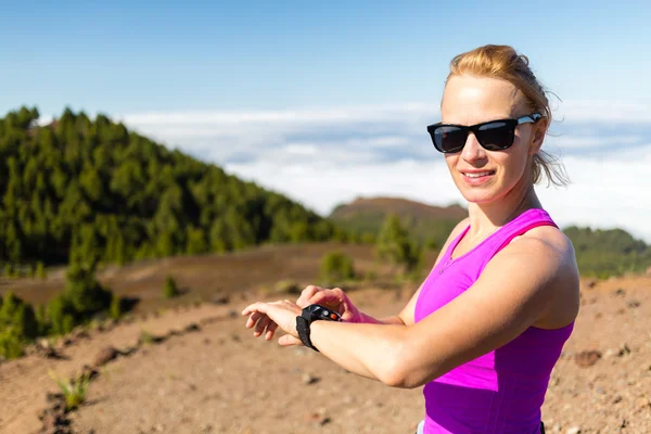 Mujer trail runner mirando el reloj deportivo —  Fotos de Stock