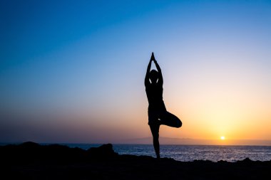Yoga ağaç günbatımı siluet yapıyor kadın