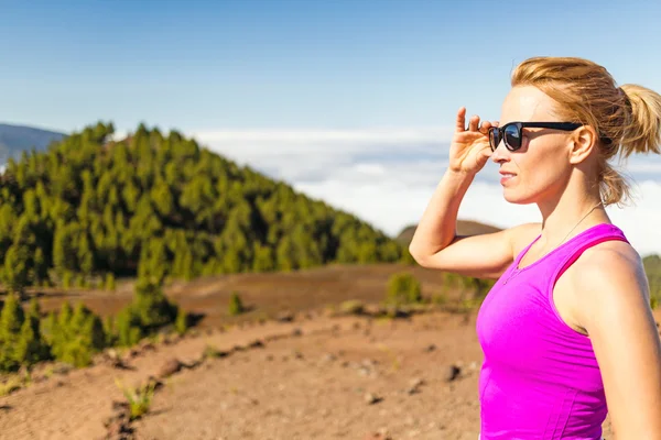 Giovane donna che corre in montagna nella soleggiata giornata estiva — Foto Stock