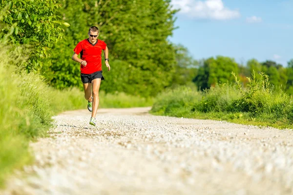 Trilho de homem correndo na estrada rural — Fotografia de Stock