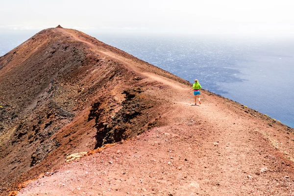 Jeune femme courant dans les montagnes sur une journée ensoleillée d'été — Photo