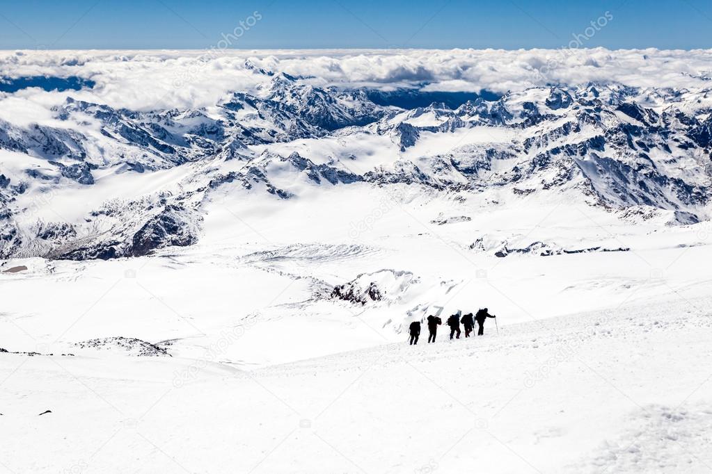 People climbing silhouette on snow in mountains