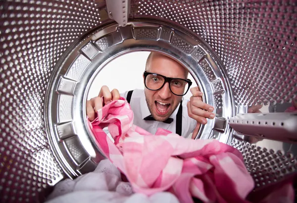 Young man doing laundry View from the inside of washing machine — Stock Photo, Image