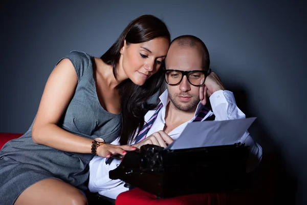 Writer and his muse, young couple freelance typing on an old typewriter — Stock Photo, Image
