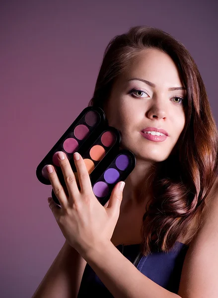 Jeune femme avec des cosmétiques de beauté — Photo