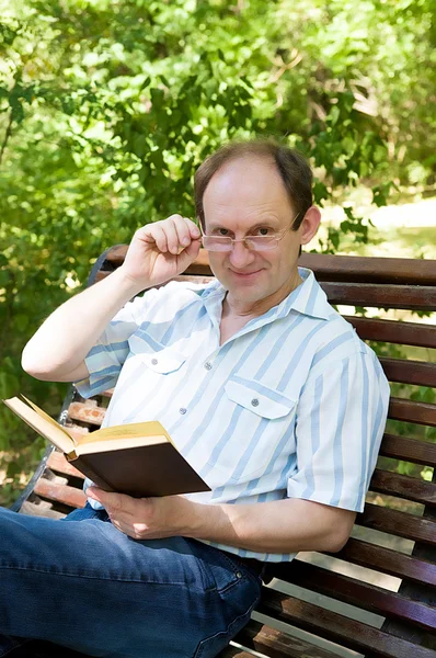 Uomo nel parco con un libro — Foto Stock