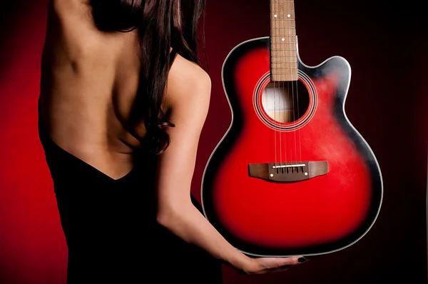 Woman with guitar on dark background — Stock Photo, Image