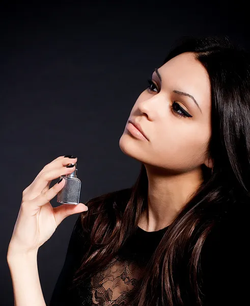 Junge brünette Frau, die Parfüm auf ihren Körper aufträgt — Stockfoto