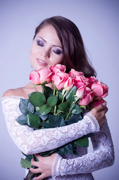 Mujer joven en vestido de novia con ramo de rosas — Foto de Stock