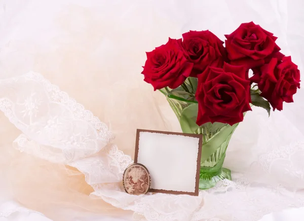 Ramo de rosas rojas con una tarjeta blanca sobre un fondo blanco — Foto de Stock