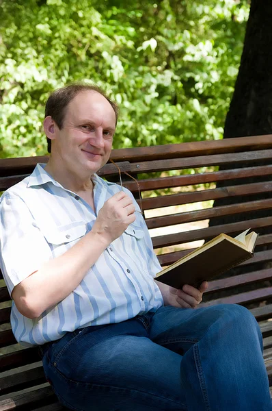 Homme dans le parc avec un livre — Photo
