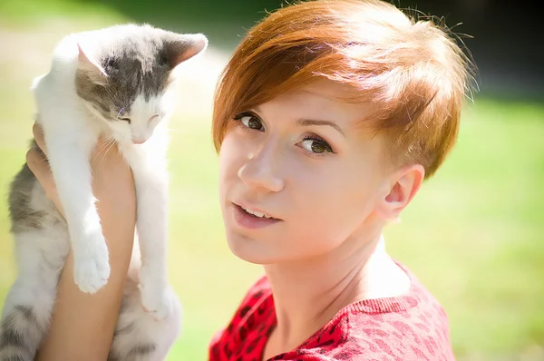 Menina bonita no parque com um gato — Fotografia de Stock