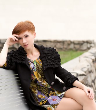 güzel kadın bir bankta oturur.