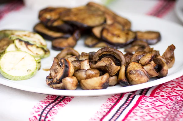Mushrooms sauteed in butter and fried zucchini on one plate — Stock Photo, Image