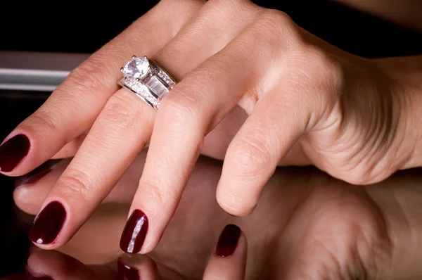 Hand met gouden sieraden op zwarte achtergrond — Stockfoto