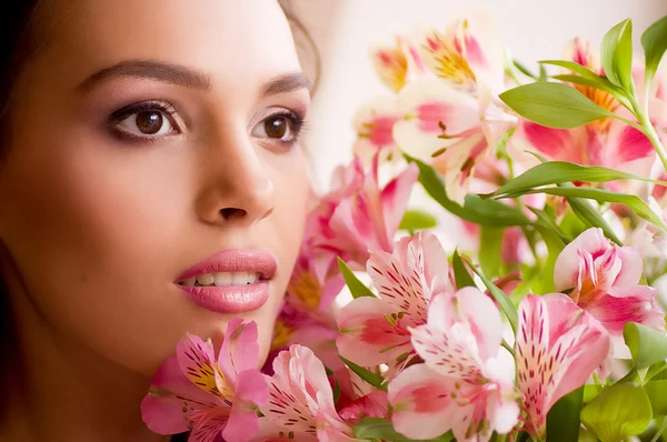 Beauty face of the young woman with pink orchid on background — Stock Photo, Image