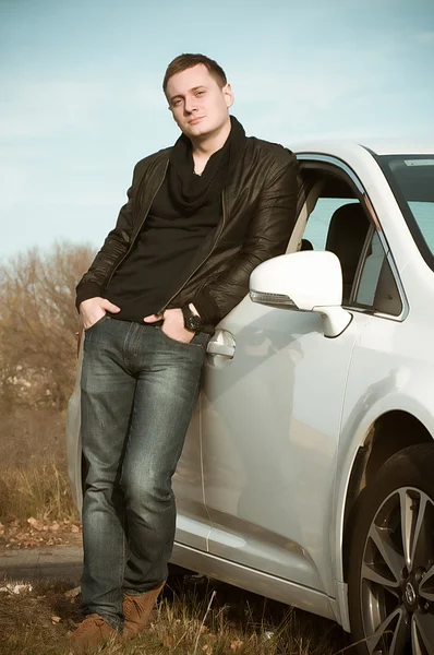 Attractive young man standing by car — Stock Photo, Image