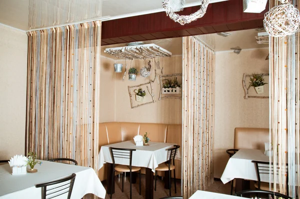 Interior of modern restaurant with the covered tables, wooden furniture — Stock Photo, Image