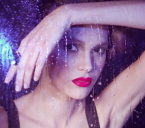 Girl watching through the rainy window — Stock Photo, Image