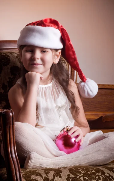 Beautiful little girl in white dress with Christmas tree decoration Stock Photo