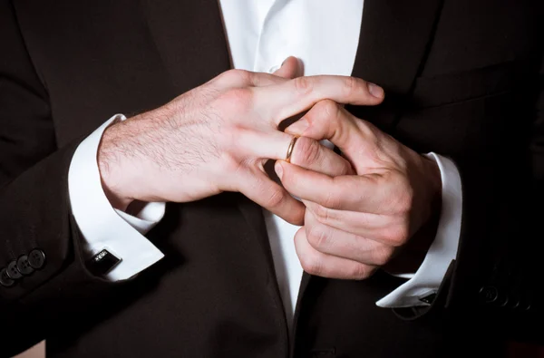 Closeup of a man in black suit correcting a sleeve — Stock Photo, Image