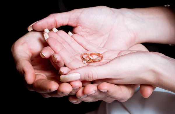 Новобрачные жених и невеста держат за руки кольца — стоковое фото