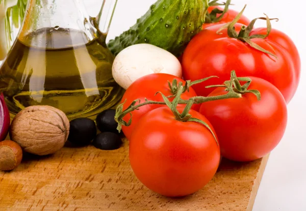 Olivenöl, Tomaten und anderes Gemüse auf weißem Hintergrund — Stockfoto