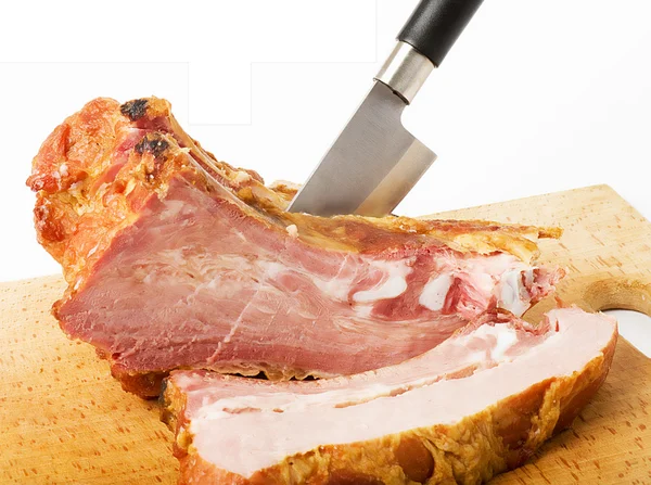 Smaczne wędzone mięso z nożem na białym tle — Zdjęcie stockowe