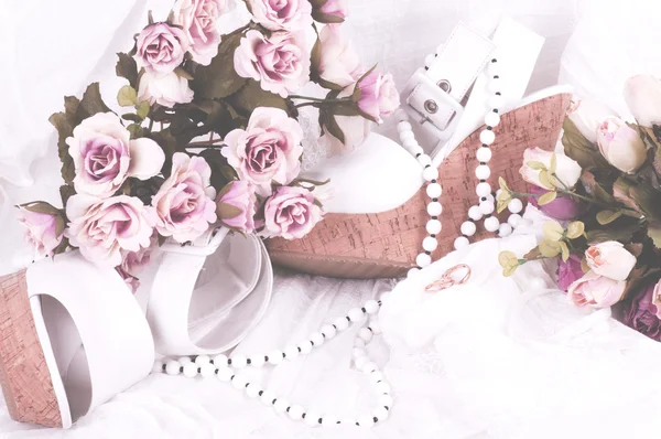 Винтажные кружева с цветами, обувью и обручальными кольцами на белом фоне — стоковое фото