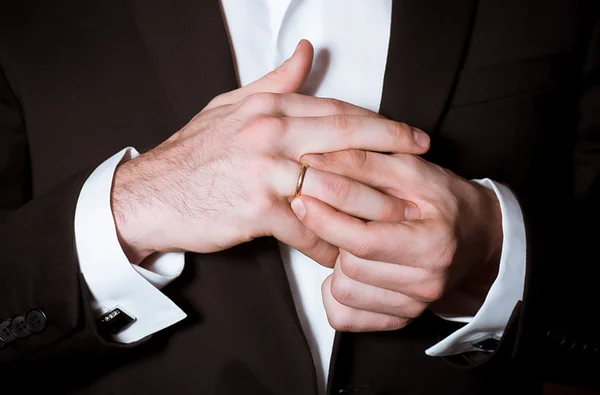 Close-up van elegantie bruidegom handen neemt af een ring — Stockfoto