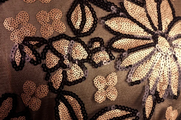 Flowers embroidered with sequins on a brown background — Stock Photo, Image