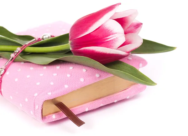 Caderno rosa e tulipas no fundo branco — Fotografia de Stock