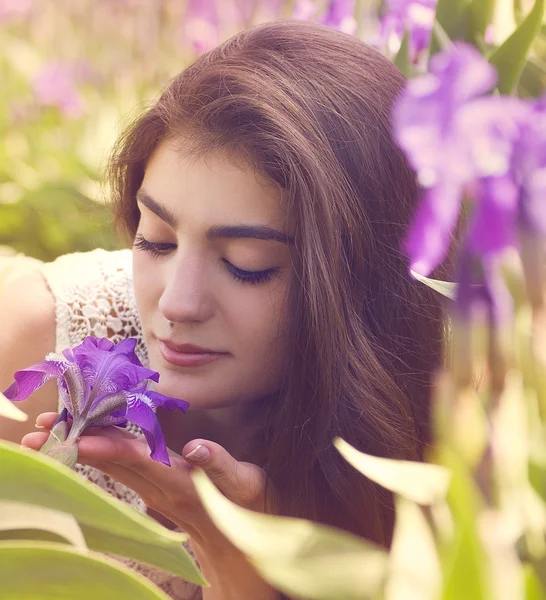 Молода жінка біля квітів ірису. Літній сад . — стокове фото