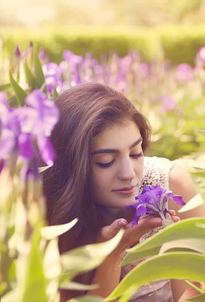 Ung kvinna nära blommande iris blommor. sommarträdgård. — Stockfoto