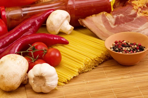 Italian raw pasta, cherry tomatoes, garlic, sauce and spices — Stock Photo, Image