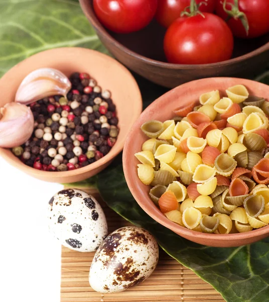 Italian raw pasta with tomatoes, quail eggs and spices — Stock Photo, Image