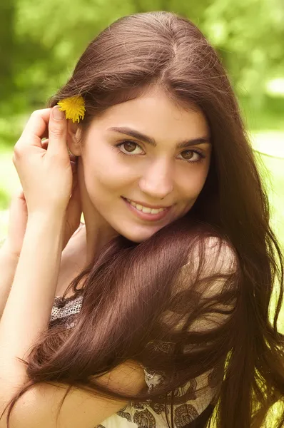 Mooi meisje in witte zomerjurk in de tuin, glimlachend — Stockfoto