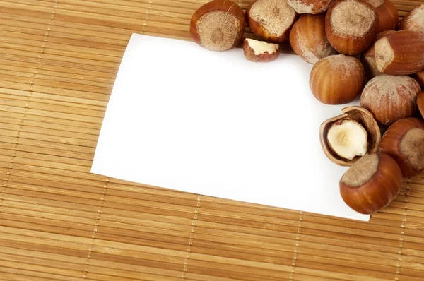Вкусные орехи с белой чистой бумагой — стоковое фото