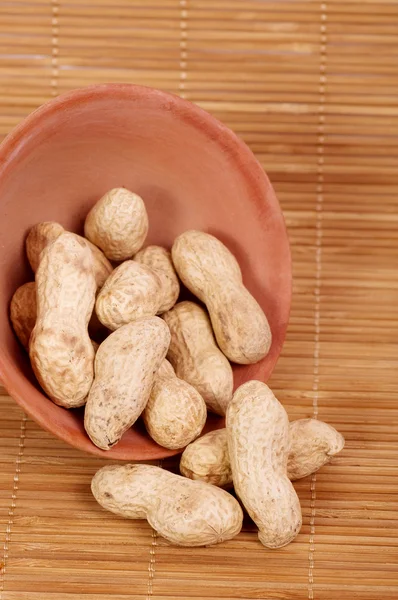 Many peanuts in a clay bowl — Stock Photo, Image