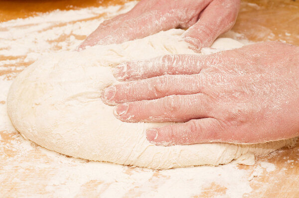 Pair of hands kneading dough