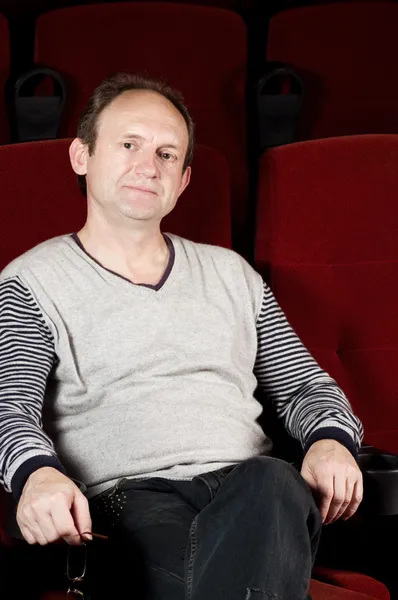 Человек сидит на красном стуле кинотеатра — стоковое фото