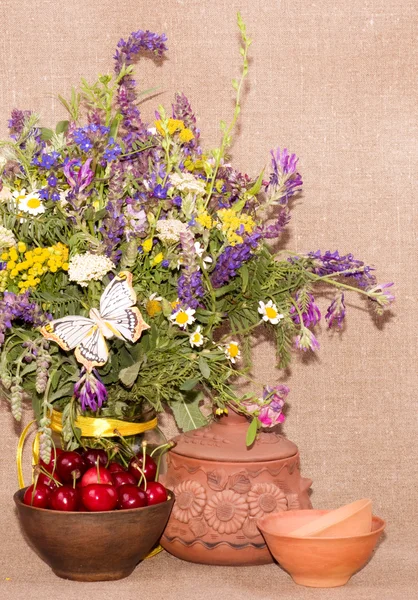 Bouquet de fleurs de champ et cerises rouges dans une assiette — Photo