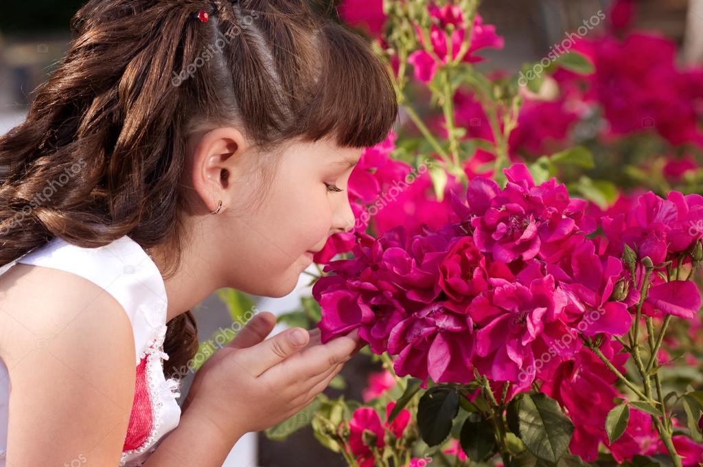 Little girl smelling flowers — Stock Photo © Forewer 26973197