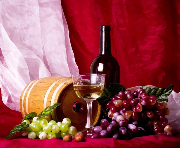 Schöne Komposition mit Wein, Traube und Fass auf rotem Hintergrund — Stockfoto