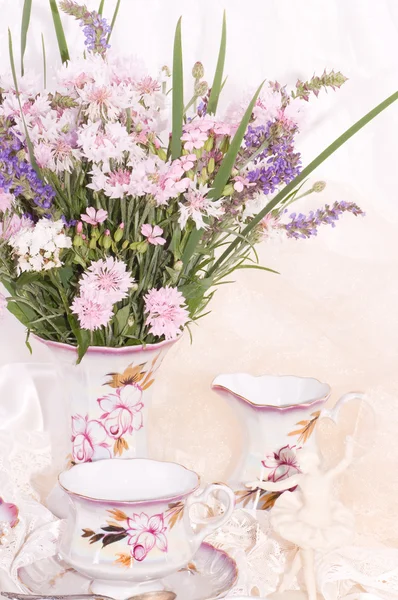 Vintage xícaras de chá, bailarino estatueta, moldura e flores — Fotografia de Stock
