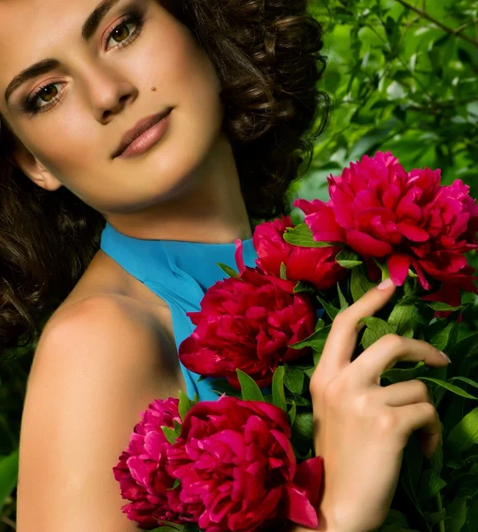 Cara de beleza da mulher jovem com flores vermelhas — Fotografia de Stock