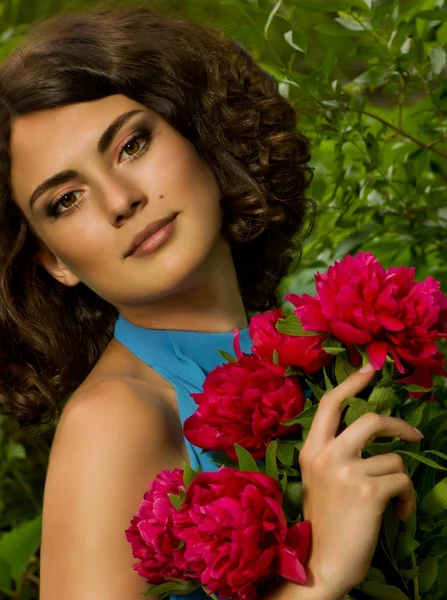 Beauty face of the young woman with red flowers — Stock Photo, Image