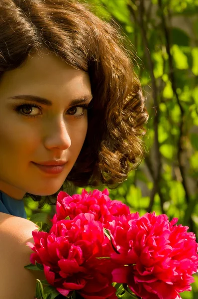 Beauty face of the young woman with red flowers — Stock Photo, Image