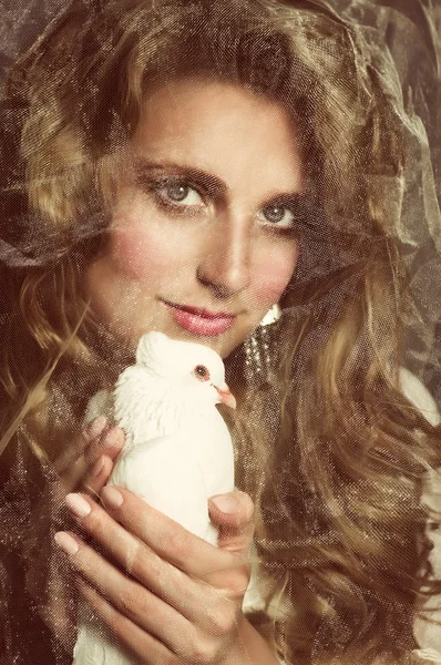 Beautiful woman with white dove on dark background — Stock Photo, Image