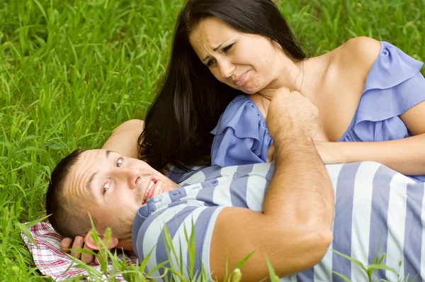 Young couple laying on park lawn — Stock Photo, Image
